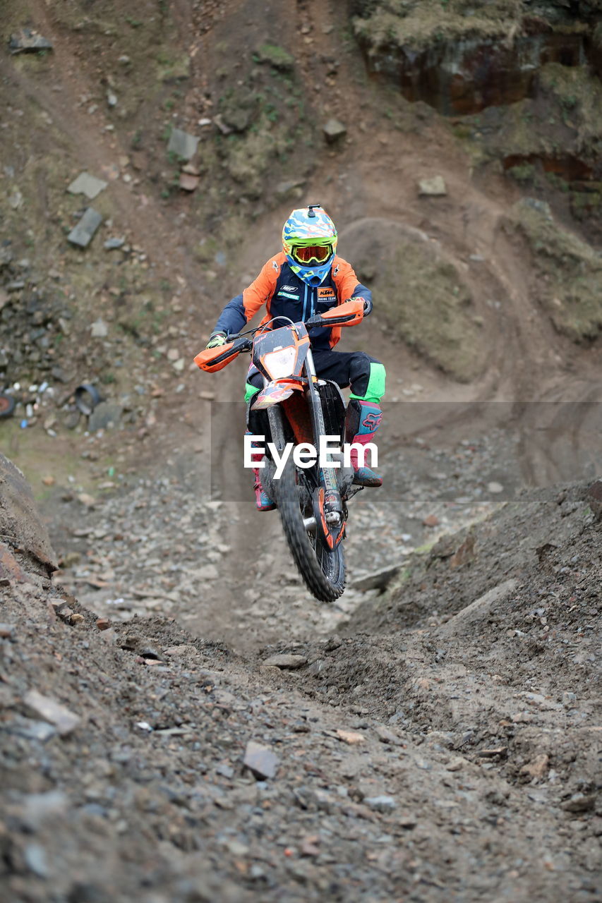 View of person riding motorcycle on dirt road