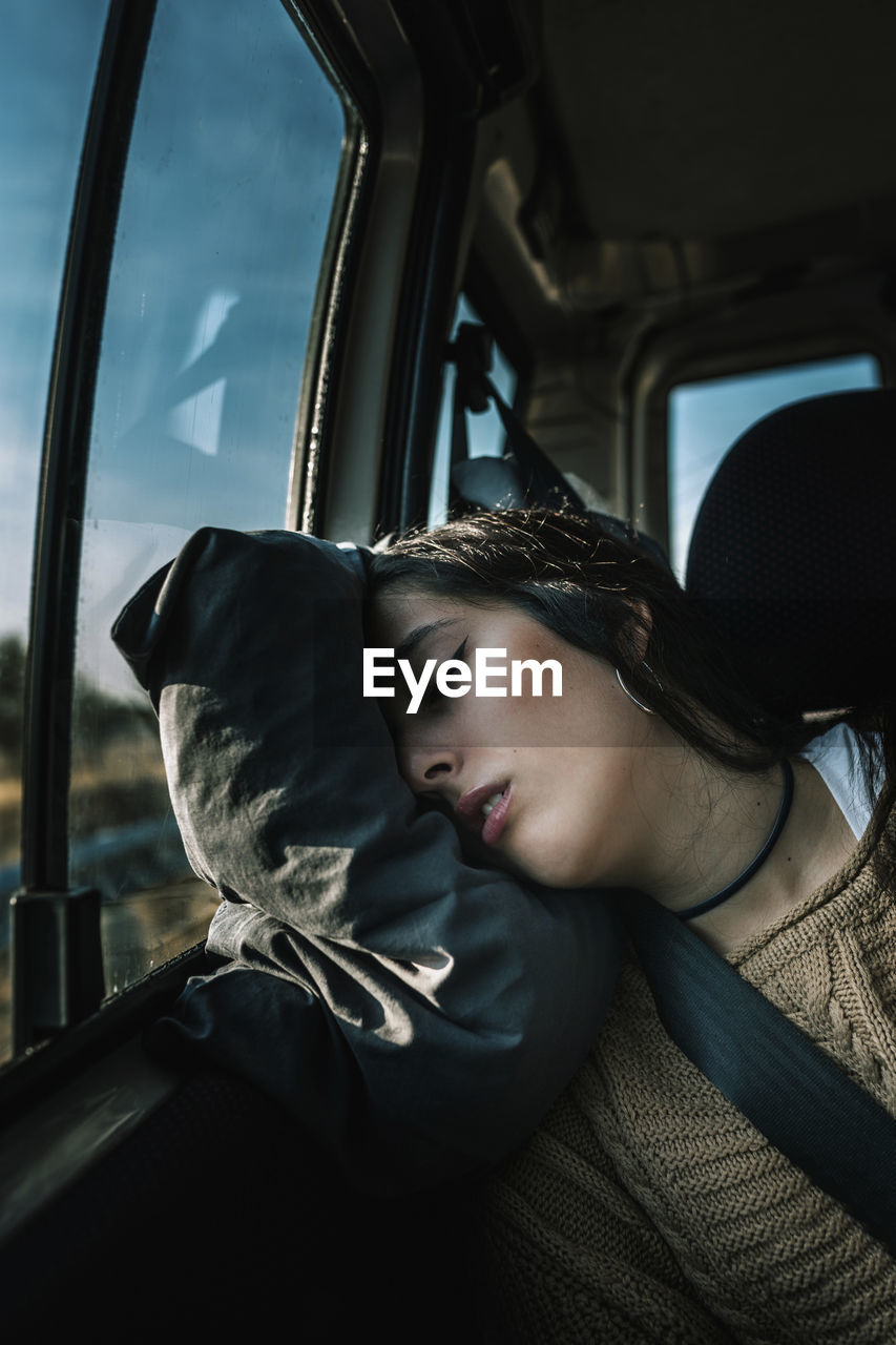 Portrait of teenage girl sleeping in car