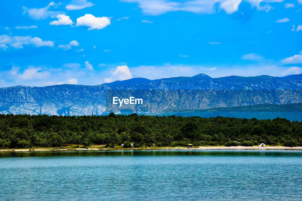 SCENIC VIEW OF LAKE AND MOUNTAINS AGAINST BLUE SKY