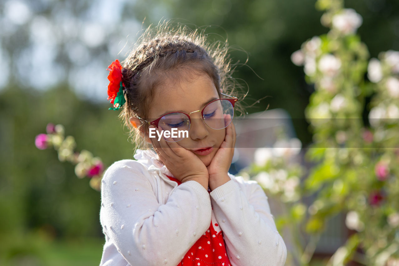 Portrait of a sad beautiful little girl in glasses