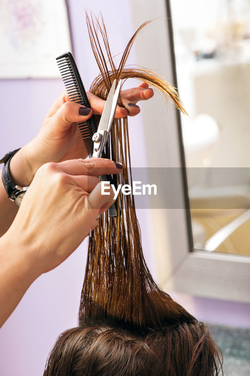 Cropped image of hairdresser with customer in salon