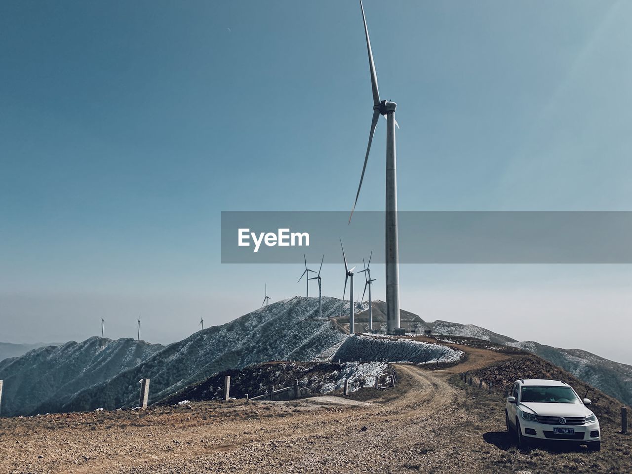 WIND TURBINES ON LANDSCAPE AGAINST SKY