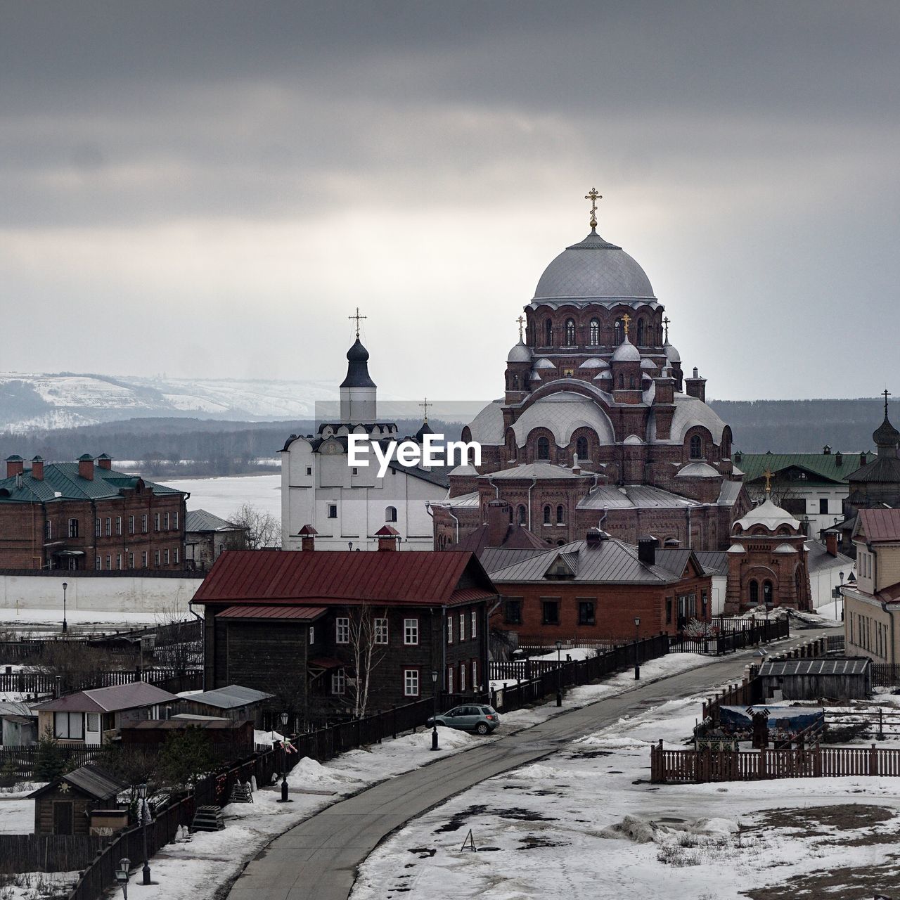 View of religious buildings in city against sky during winter