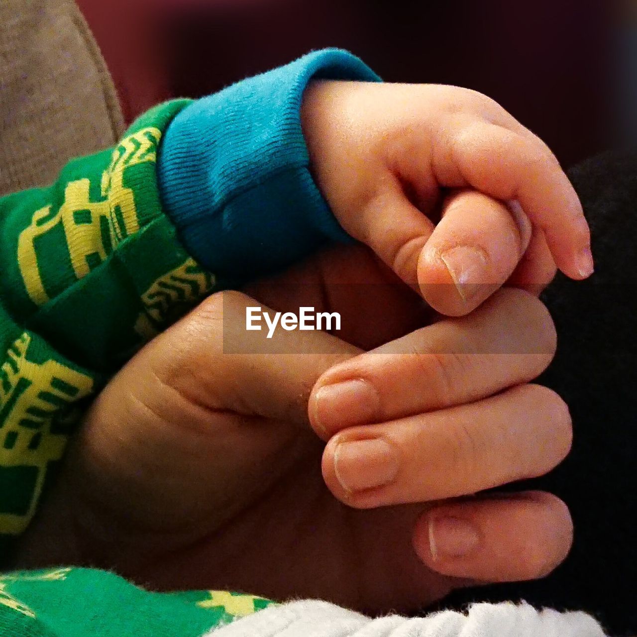 CLOSE-UP OF BABY HOLDING HANDS