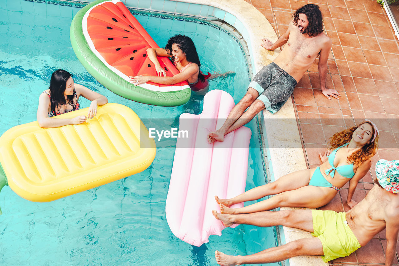 High angle view of people relaxing by swimming pool