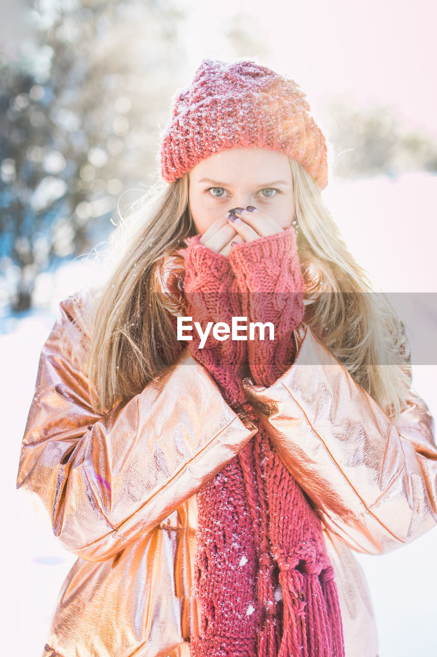 Portrait of woman against trees on snowy field