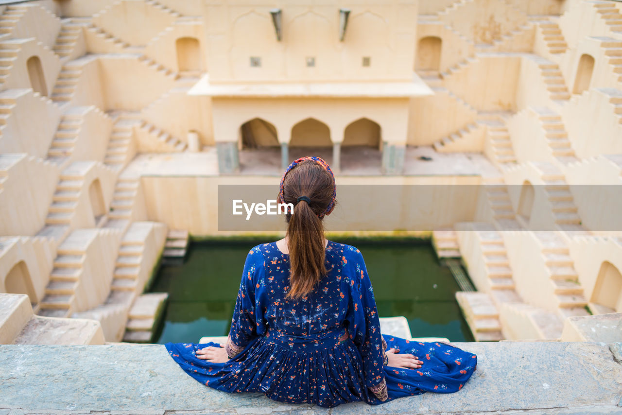 Rear view of woman sitting at chand baori