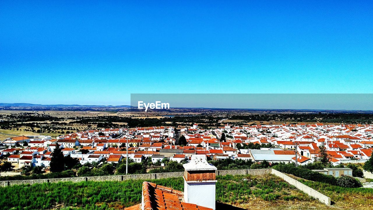 AERIAL VIEW OF TOWN AGAINST CLEAR BLUE SKY