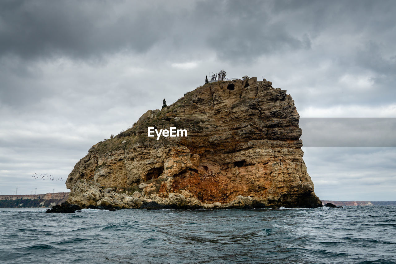 Rock formations by sea against sky