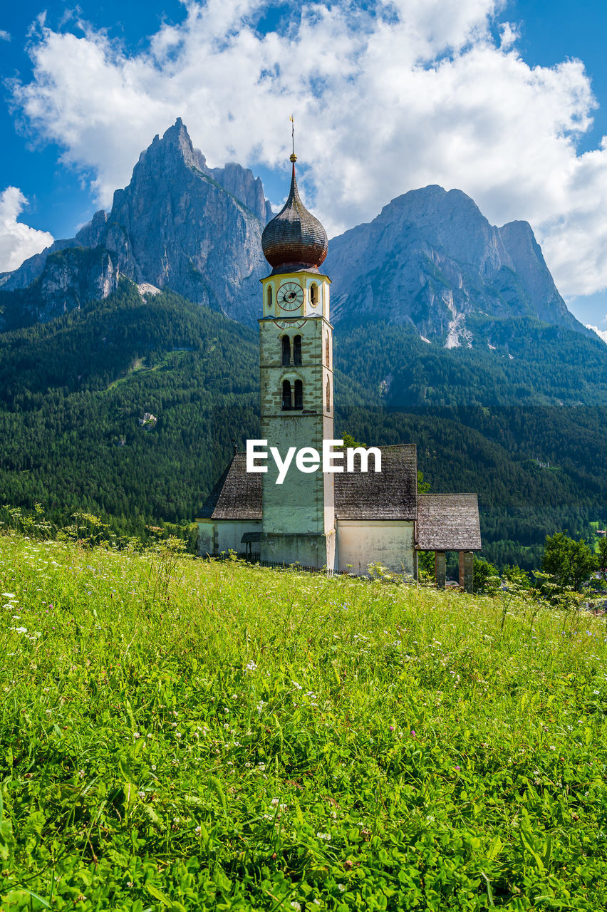 TEMPLE BY BUILDING AGAINST MOUNTAINS