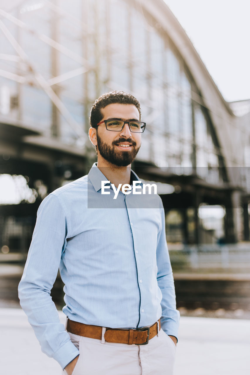 Young man standing at railroad station platform