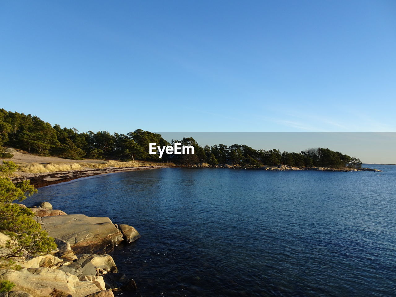 Scenic view of lake against clear blue sky