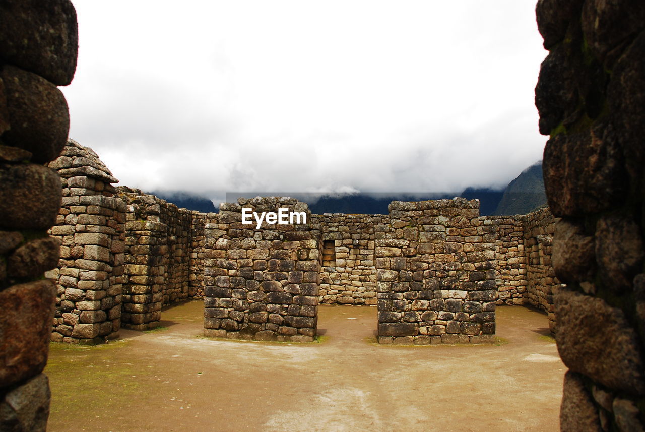 Old stone walls at machu picchu in foggy weather