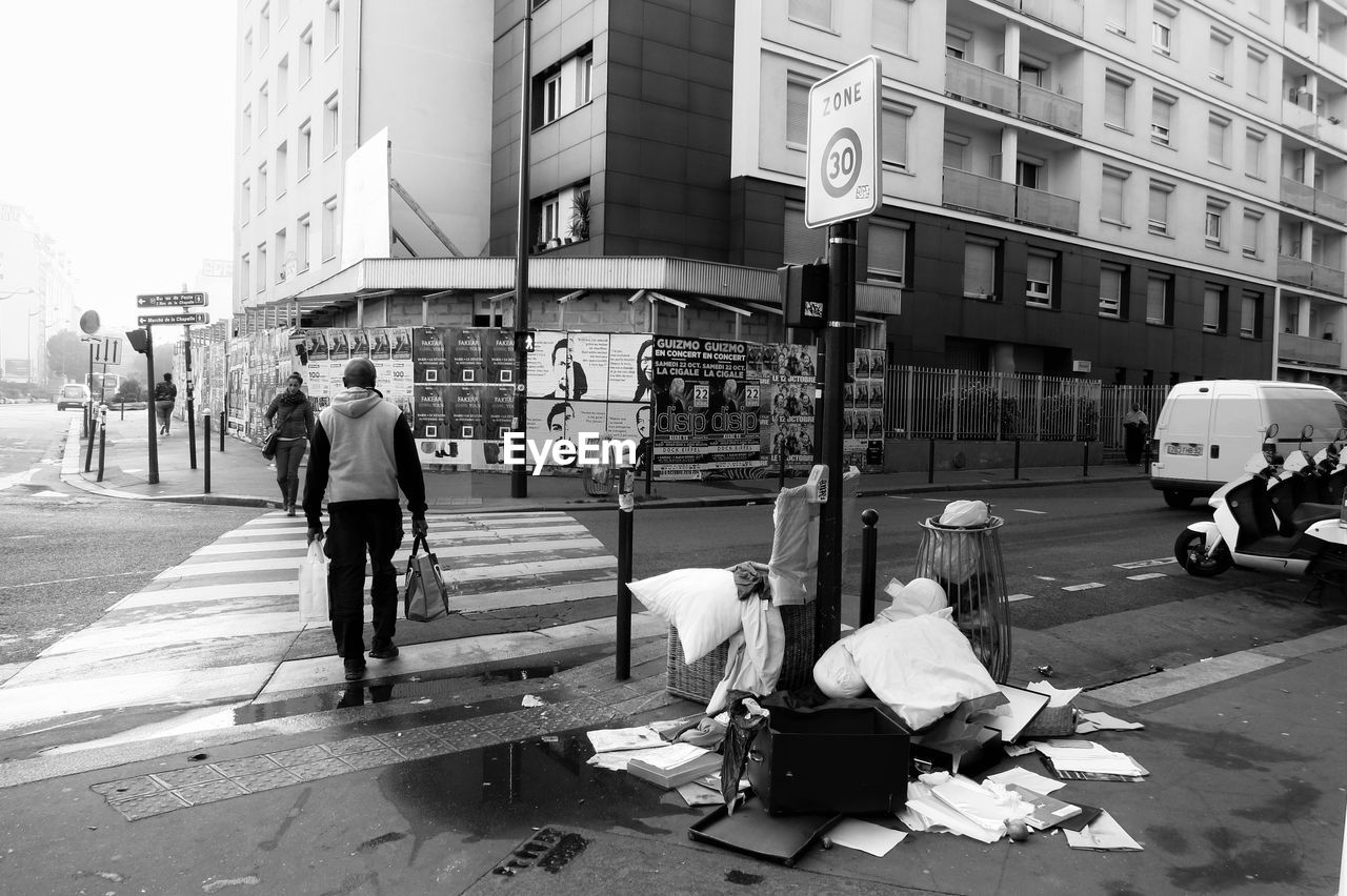 PEOPLE WALKING ON ROAD IN CITY