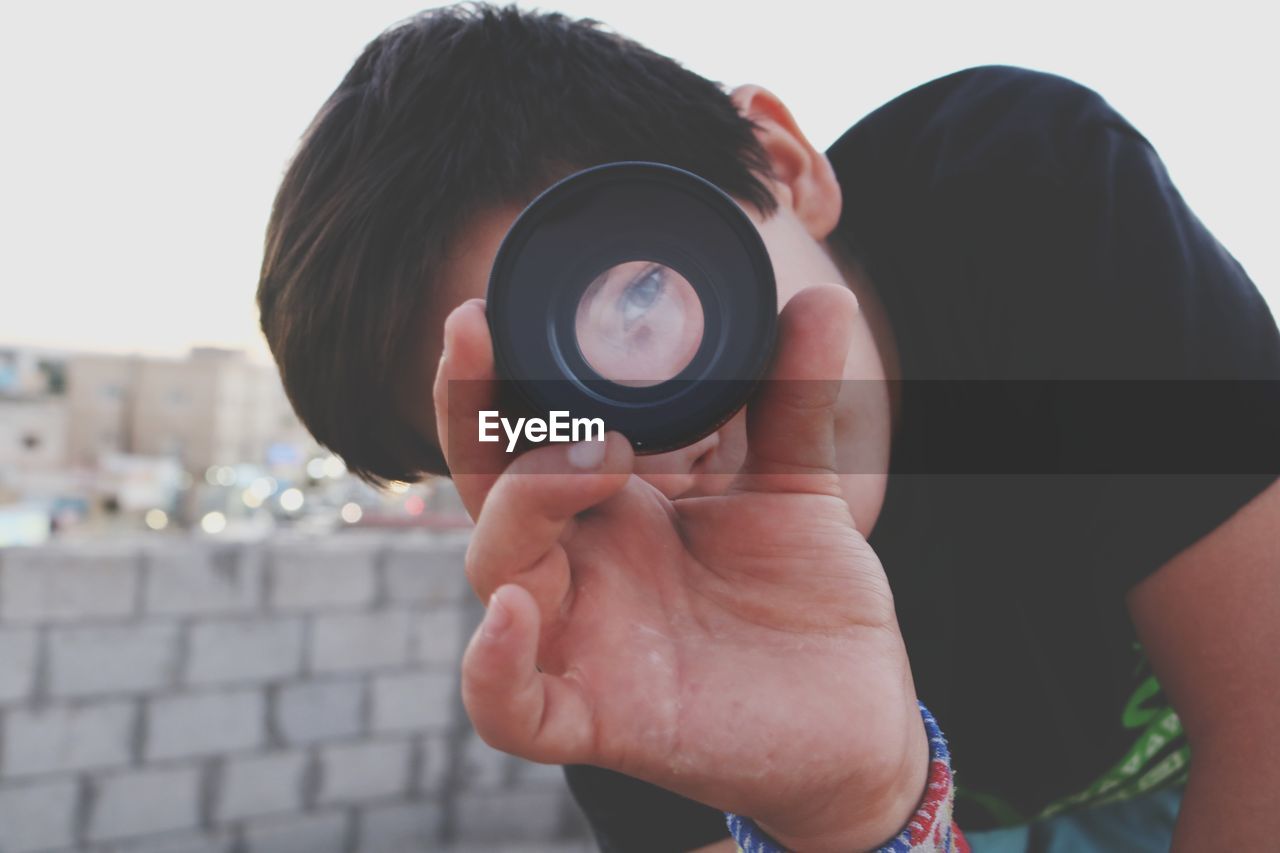 Portrait of boy looking through camera lens