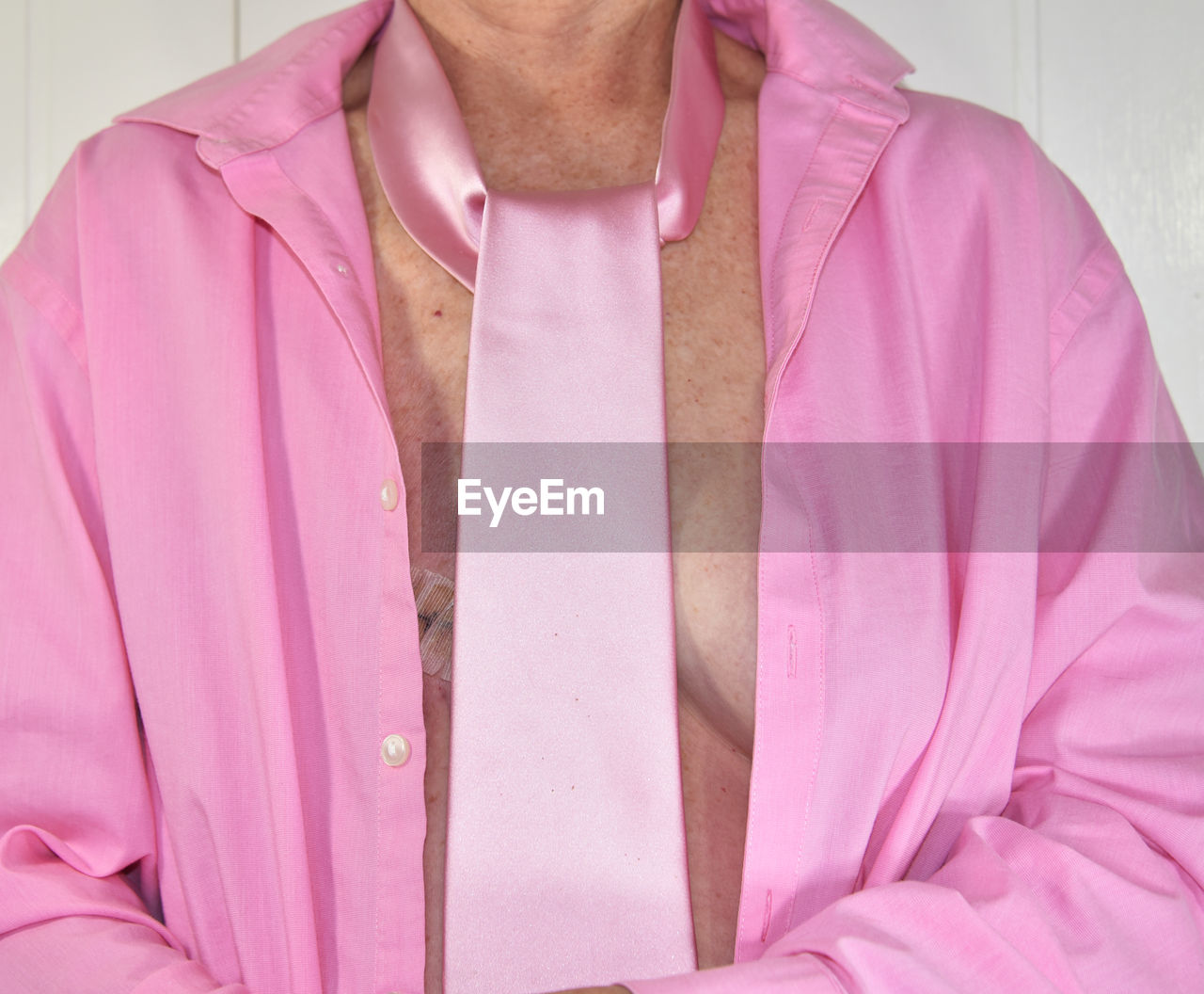 Midsection woman wearing pink shirt and tie