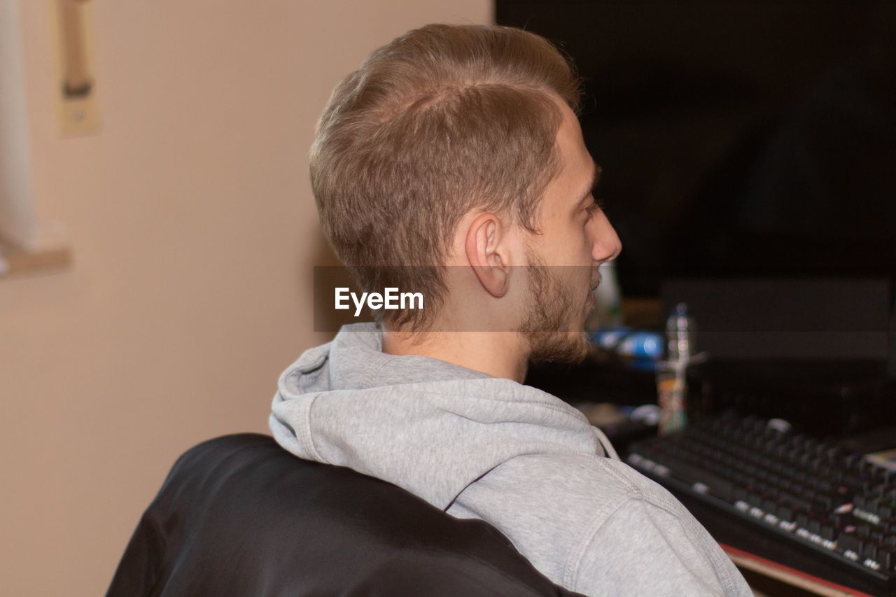 Musician looking at computer in recording studio