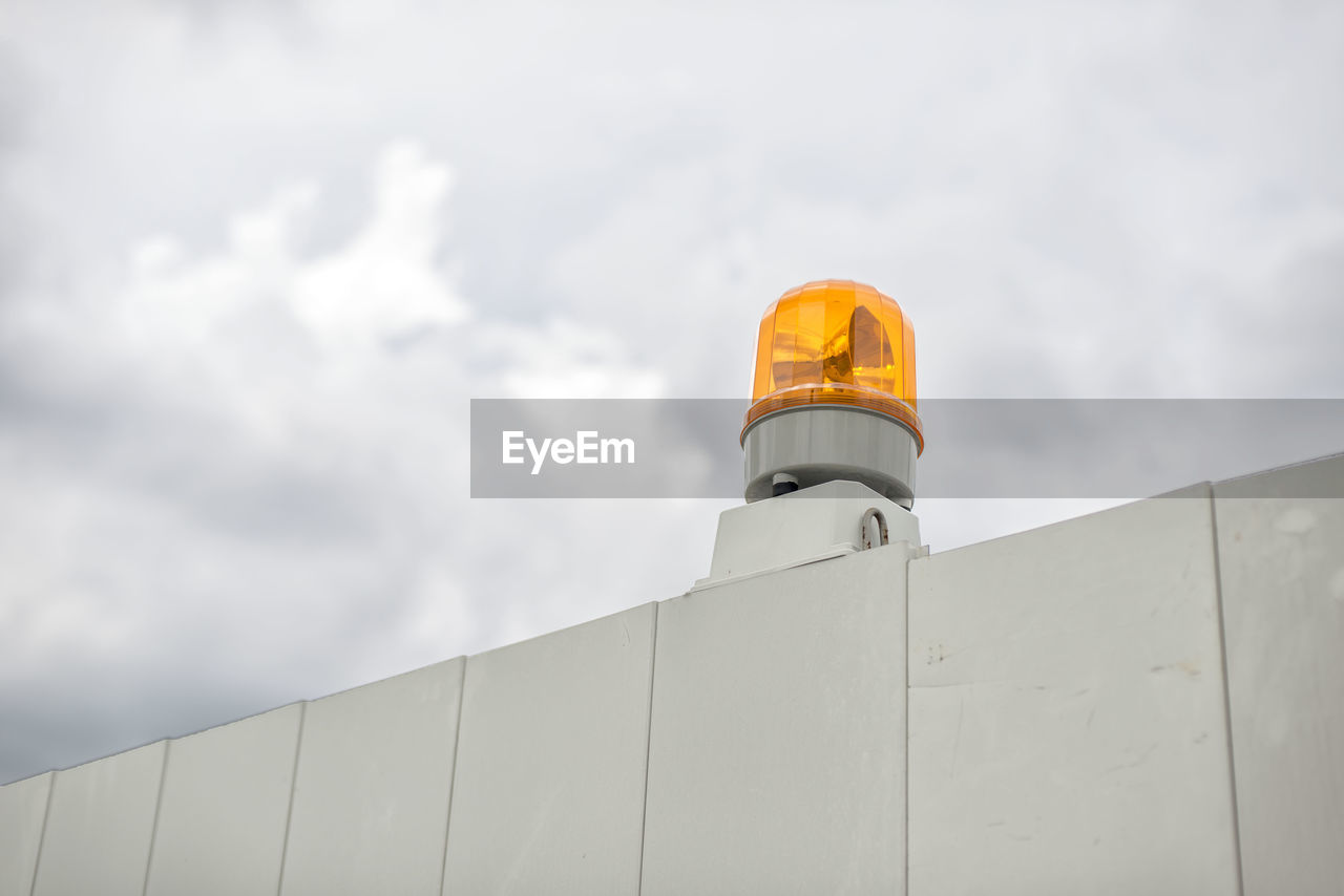 Low angle view of fence with a flasher light