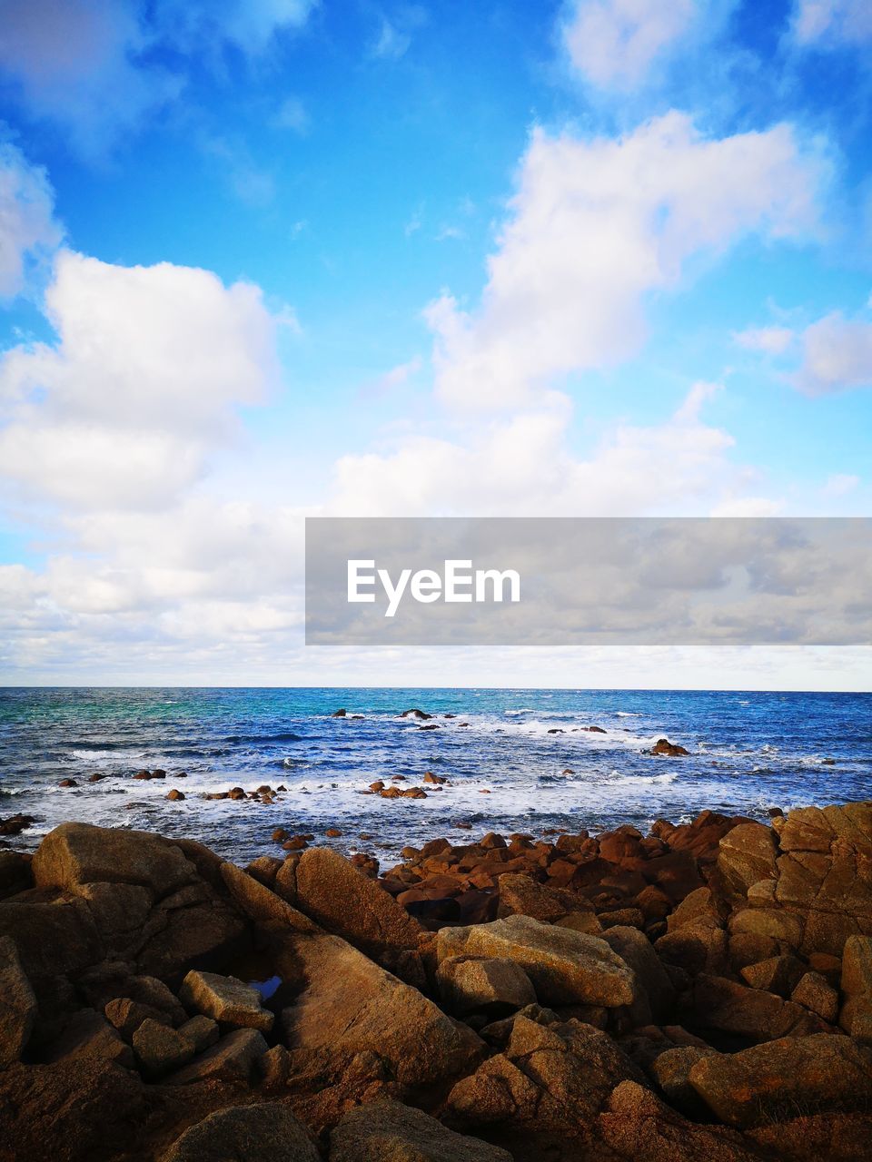 SCENIC VIEW OF SEA BY ROCKS AGAINST SKY