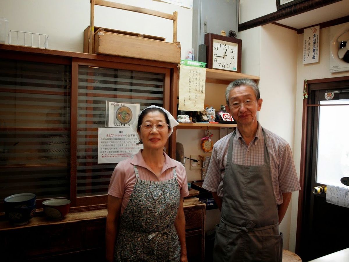 PORTRAIT OF HAPPY MAN STANDING IN STORE