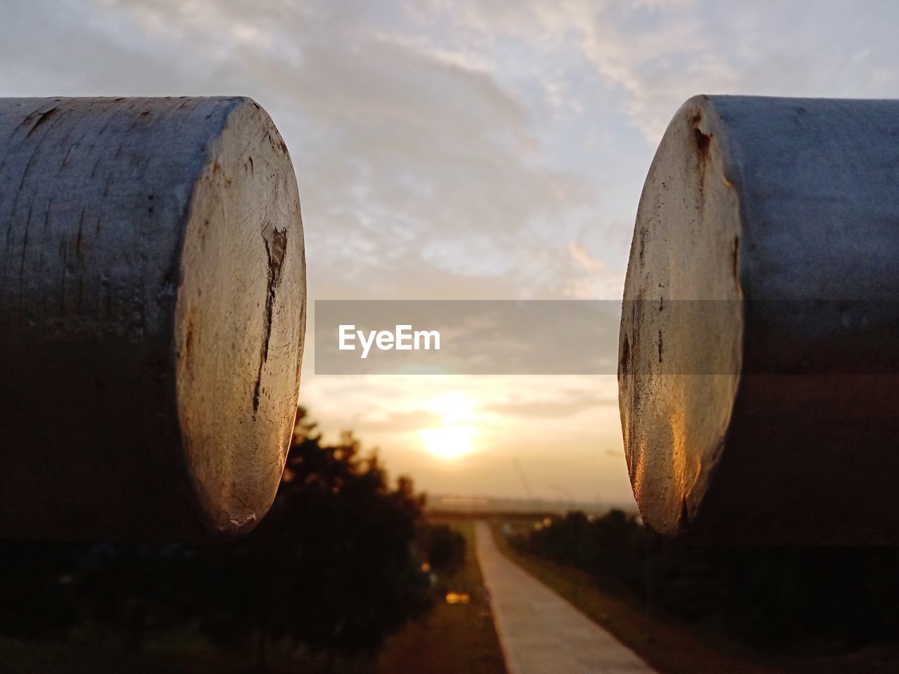 Close-up of metal structure on land against sky during sunset