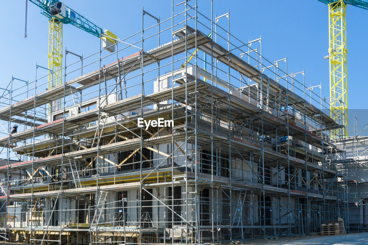 LOW ANGLE VIEW OF CONSTRUCTION SITE AGAINST BUILDING