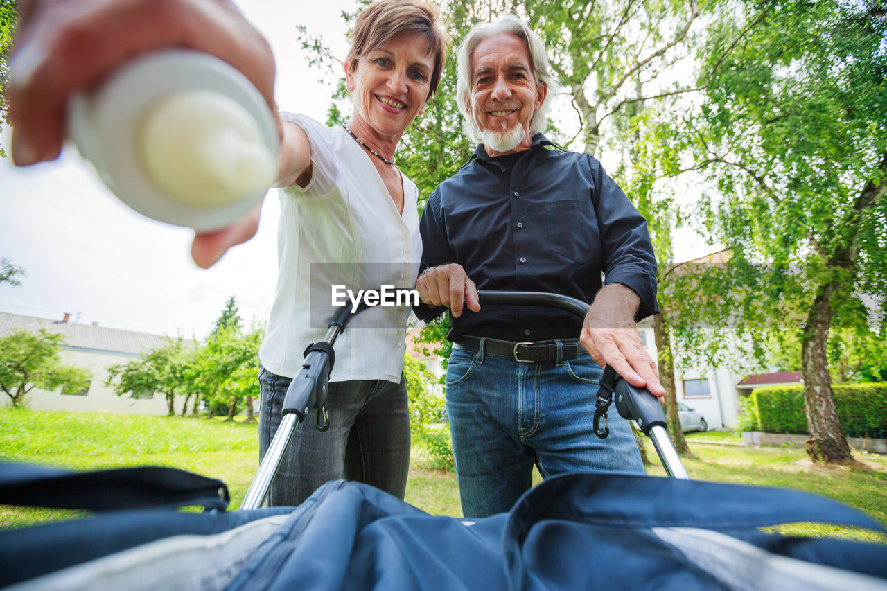 Portrait of senior couple with baby stroller