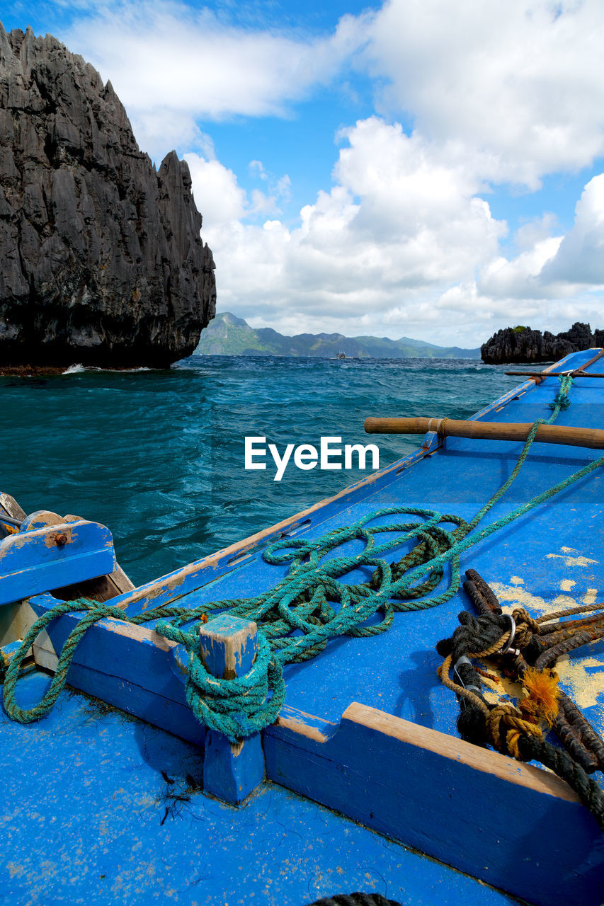 FISHING BOATS MOORED AT SEA AGAINST SKY