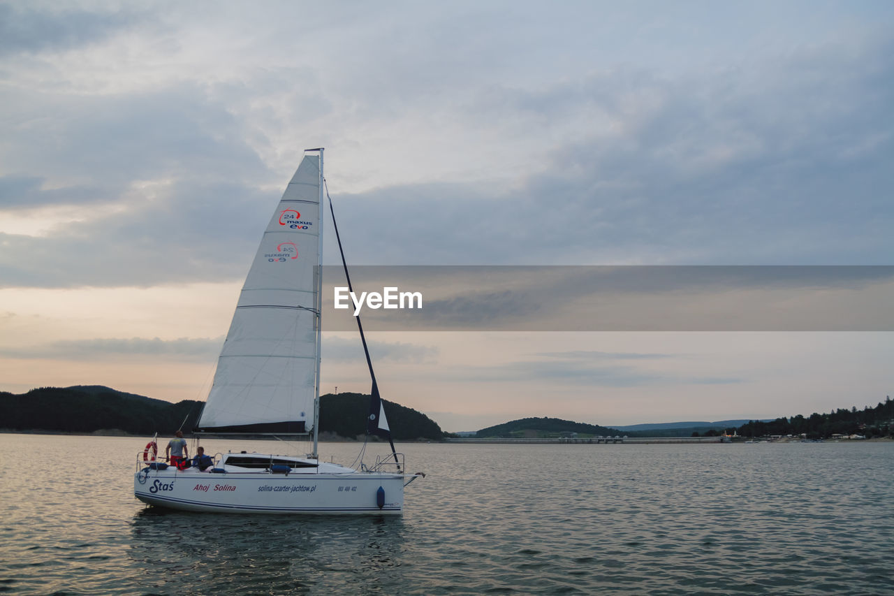 SAILBOAT SAILING ON SEA AGAINST SKY AT SUNSET