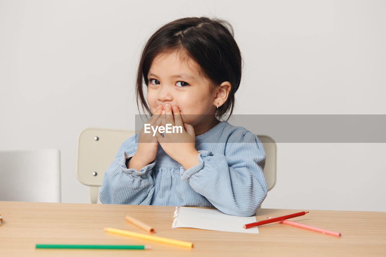 Portrait of girl with color pencil at home