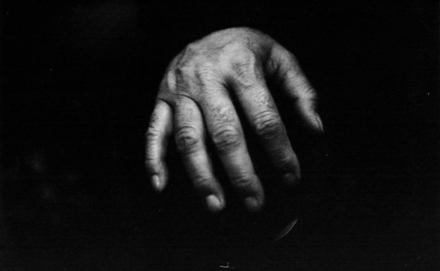 CLOSE-UP OF HANDS OVER BLACK BACKGROUND