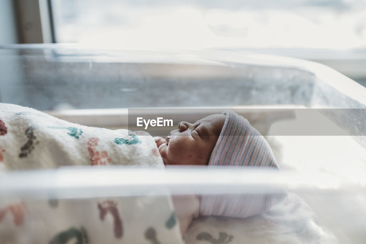 Side view of newborn boy profile with hat in hospital