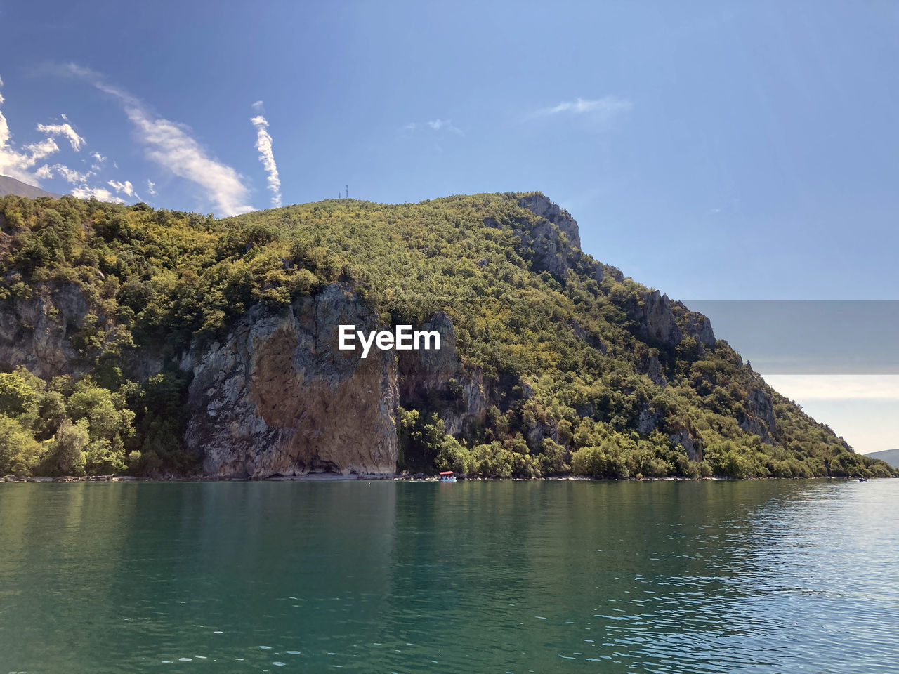 Ohrid lake on background mountains with forest and blue sky