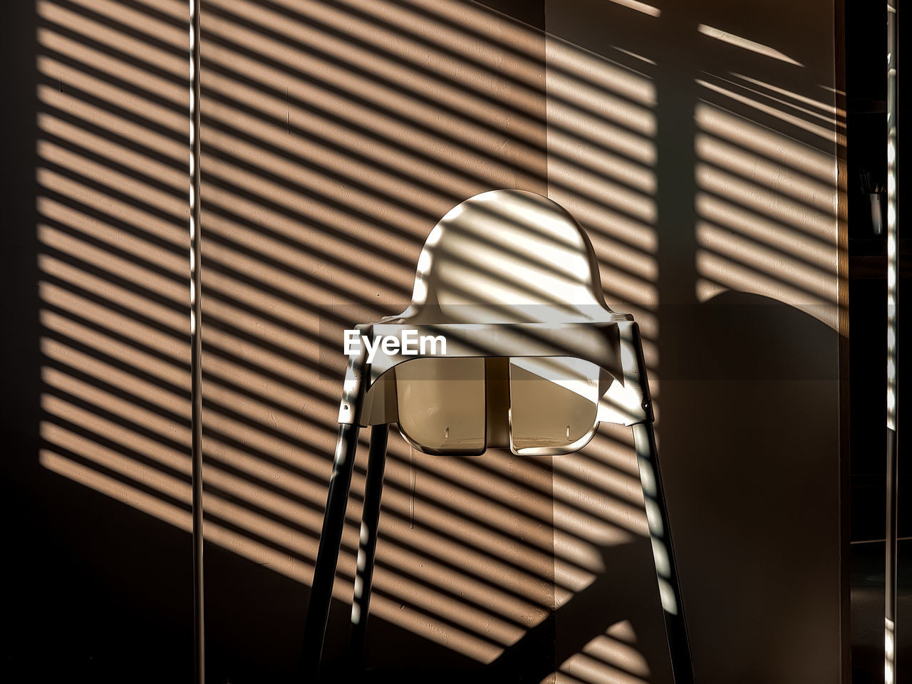 Shadows in the interior, children's chair and shadow stripes.