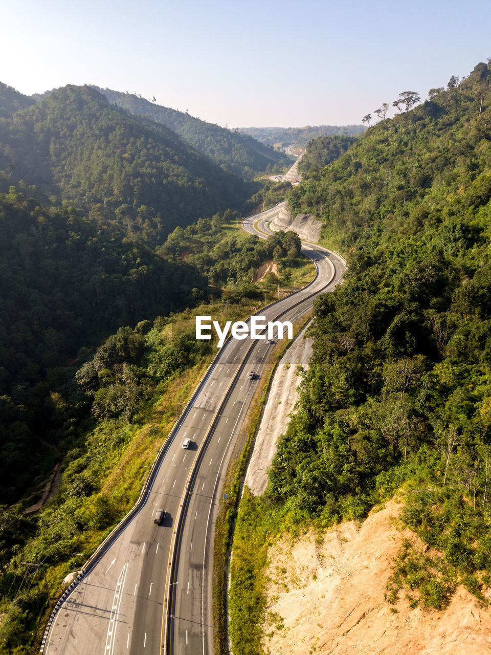 High angle view of road amidst trees against sky