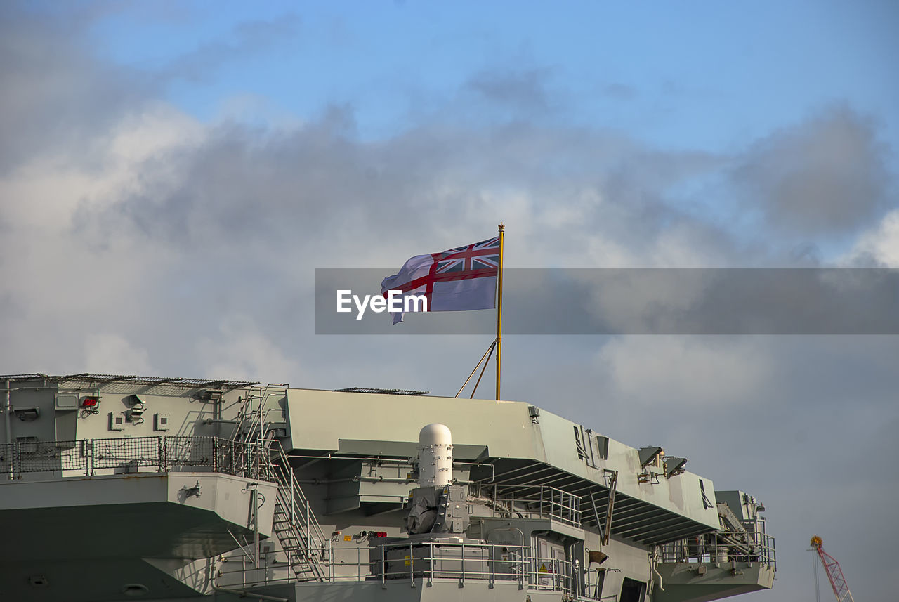 LOW ANGLE VIEW OF FLAG AGAINST BUILDINGS IN CITY