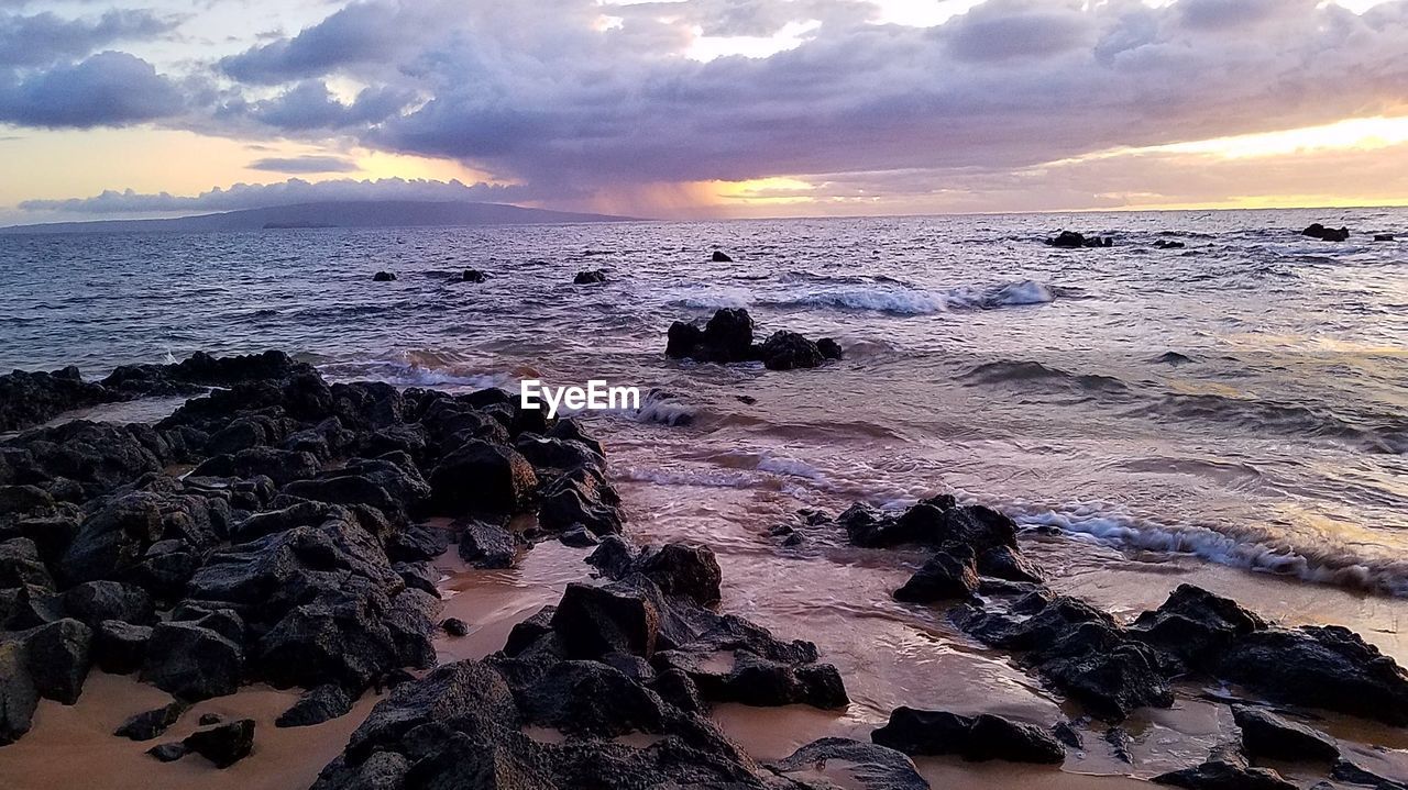 SCENIC VIEW OF BEACH AGAINST SKY DURING SUNSET