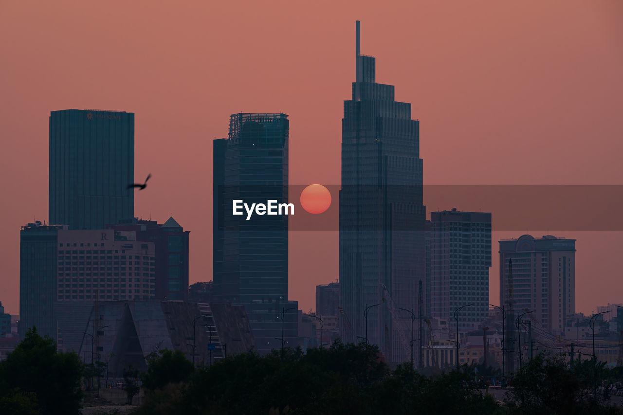 SKYSCRAPERS IN CITY AGAINST SUNSET SKY