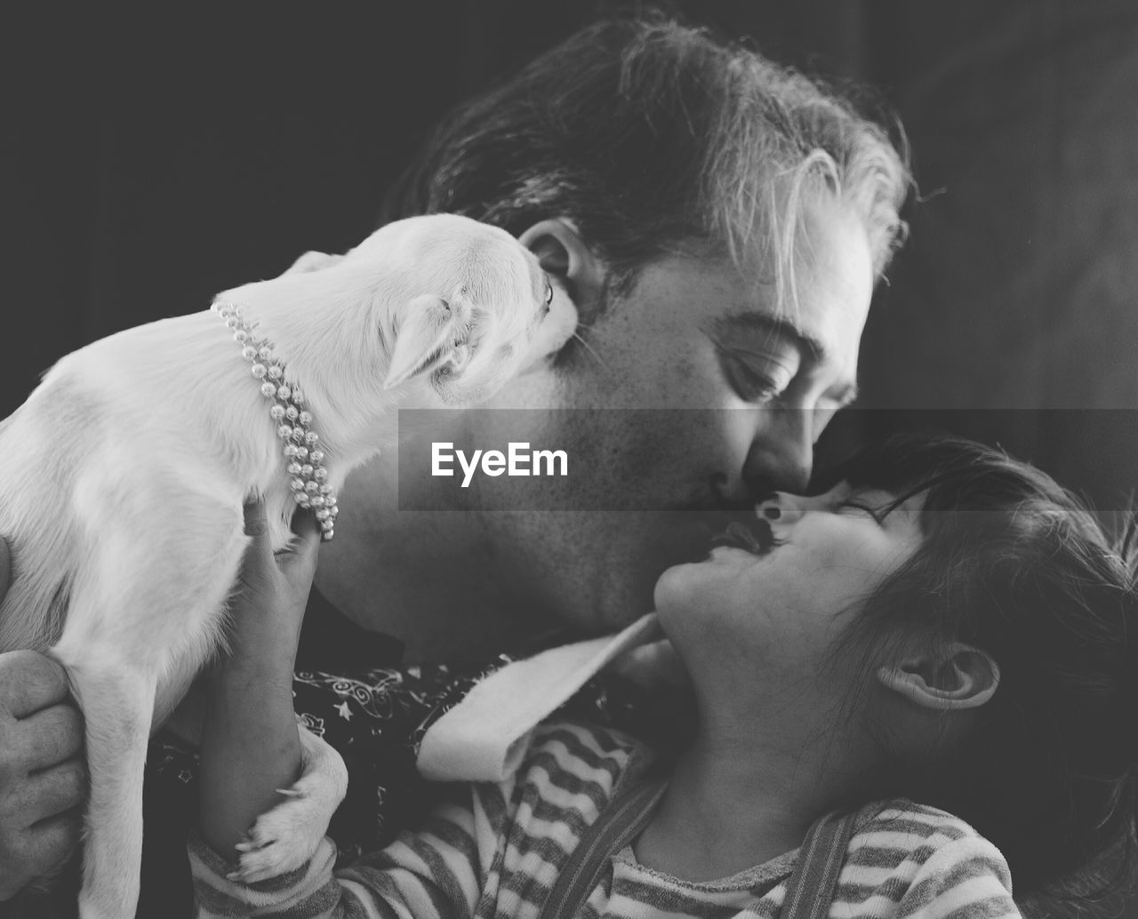 Father and daughter embracing while holding dog