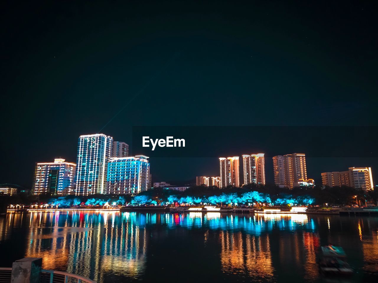 Illuminated buildings against sky at night