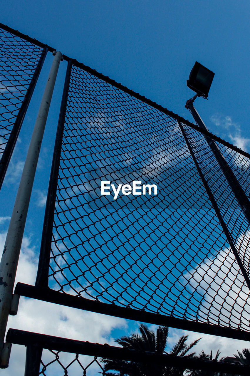 Low angle view of chainlink fence against sky