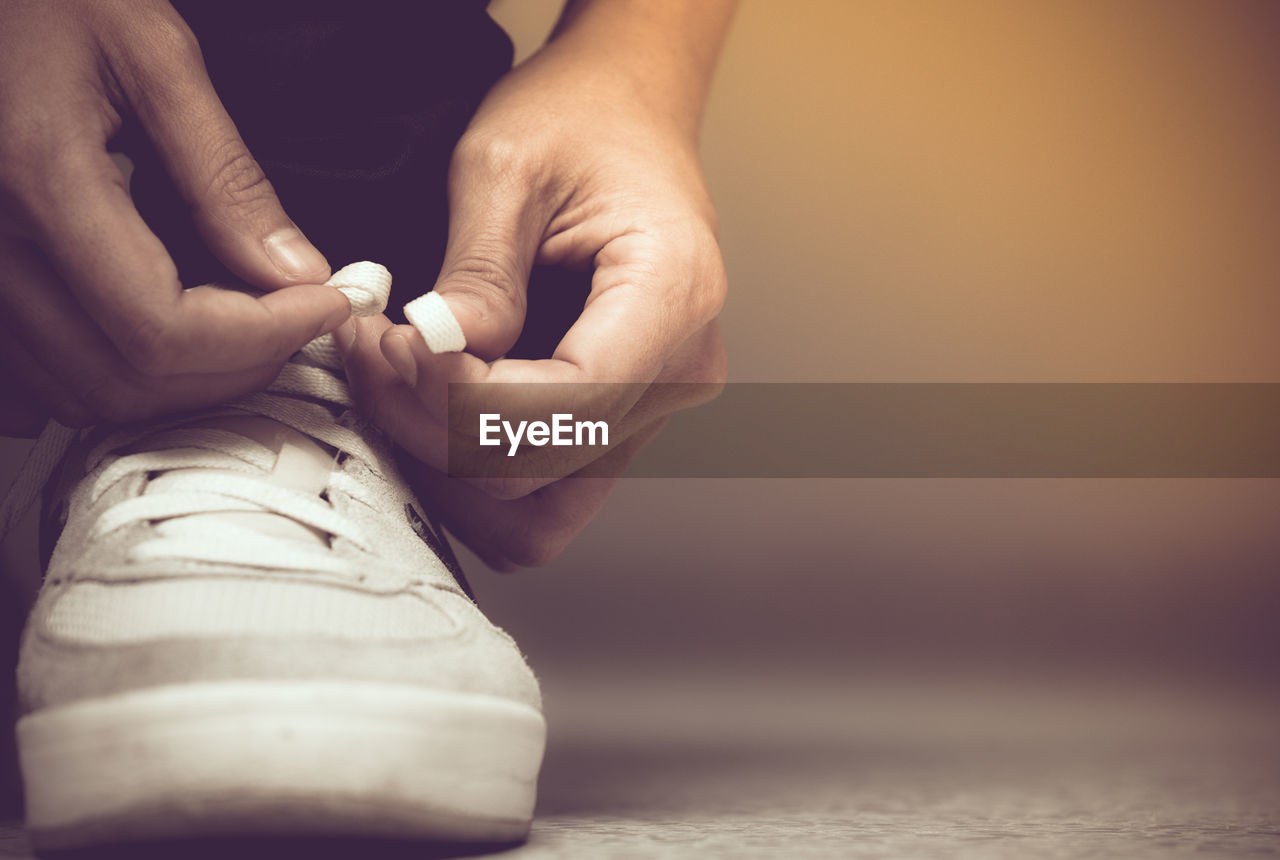 Low section of man tying shoelace