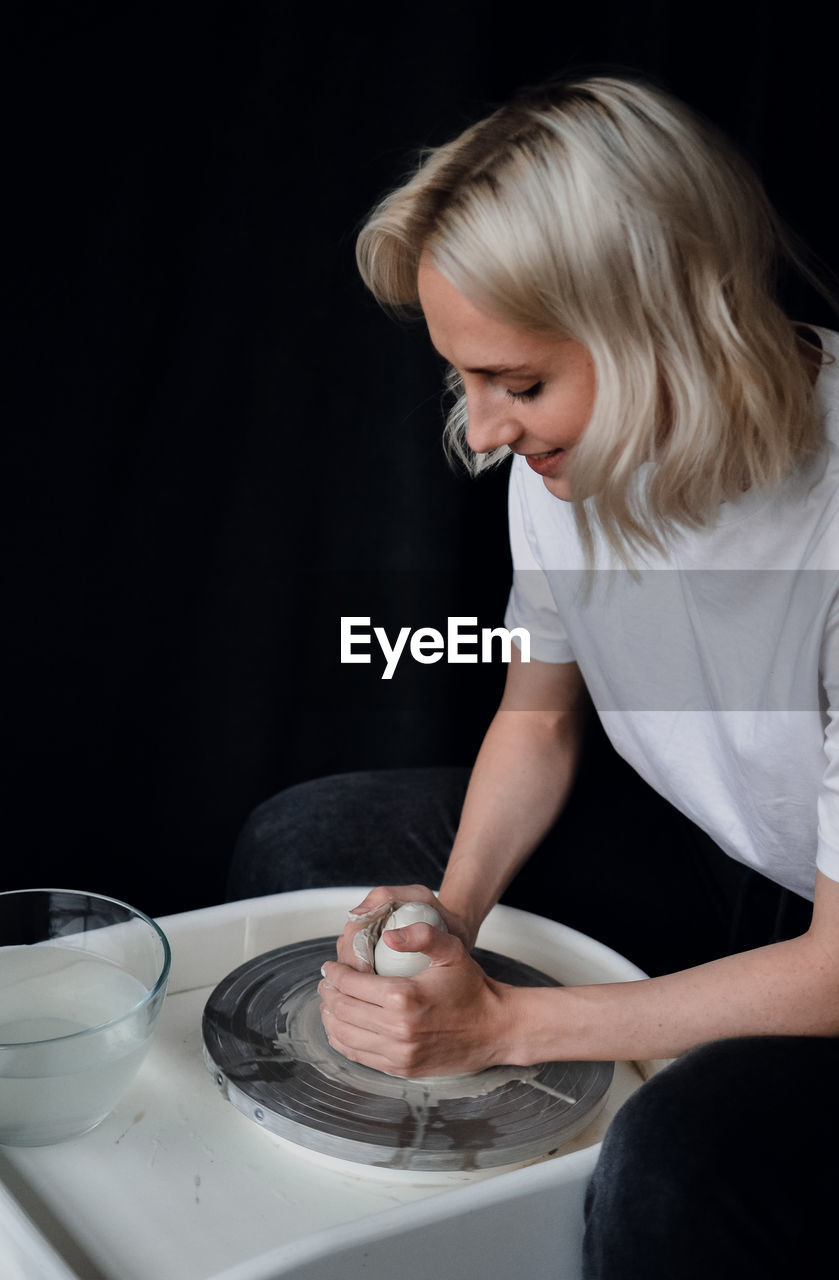 Ceramist works behind a potter's wheel