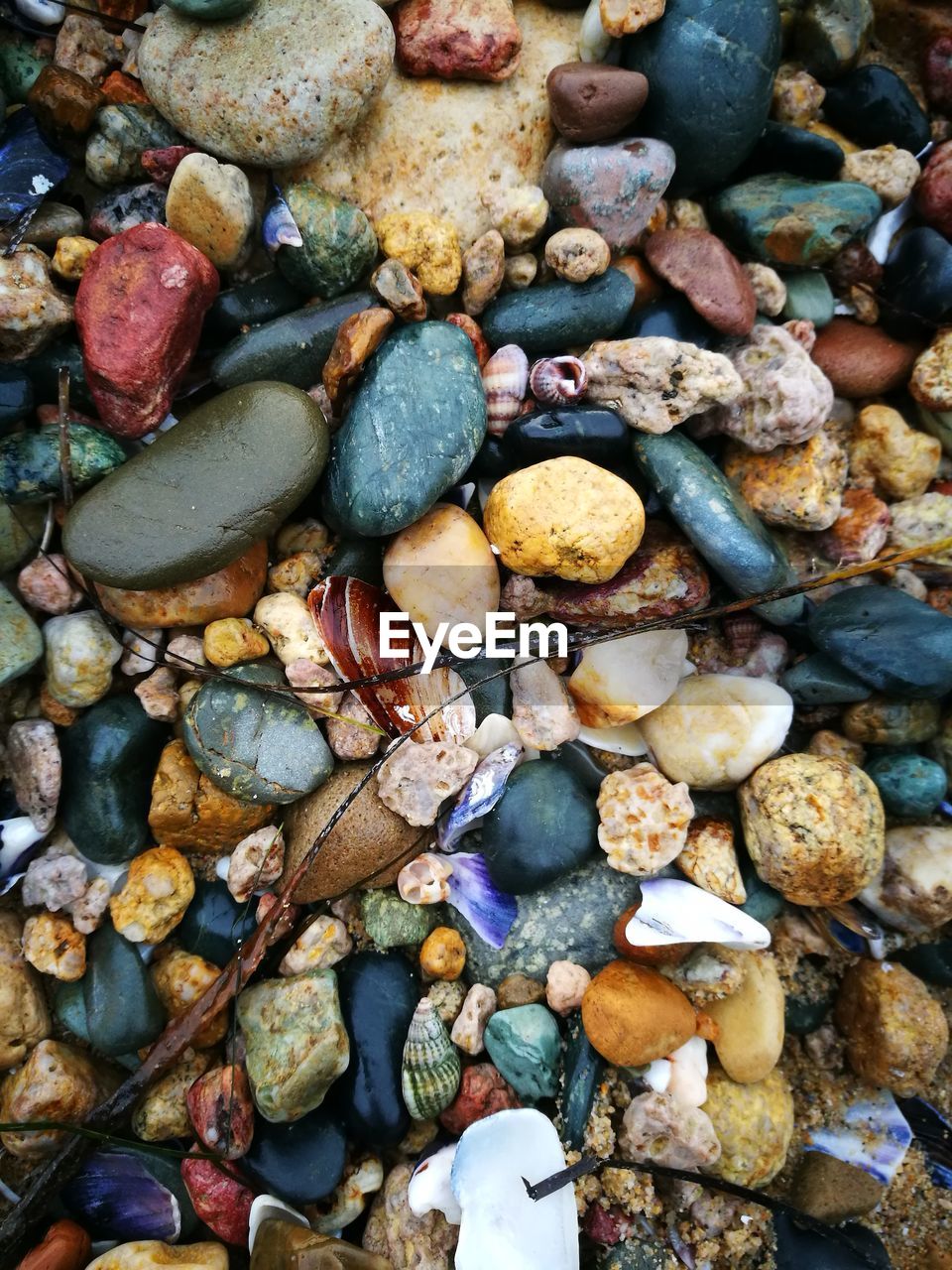 HIGH ANGLE VIEW OF STONES ON PEBBLES