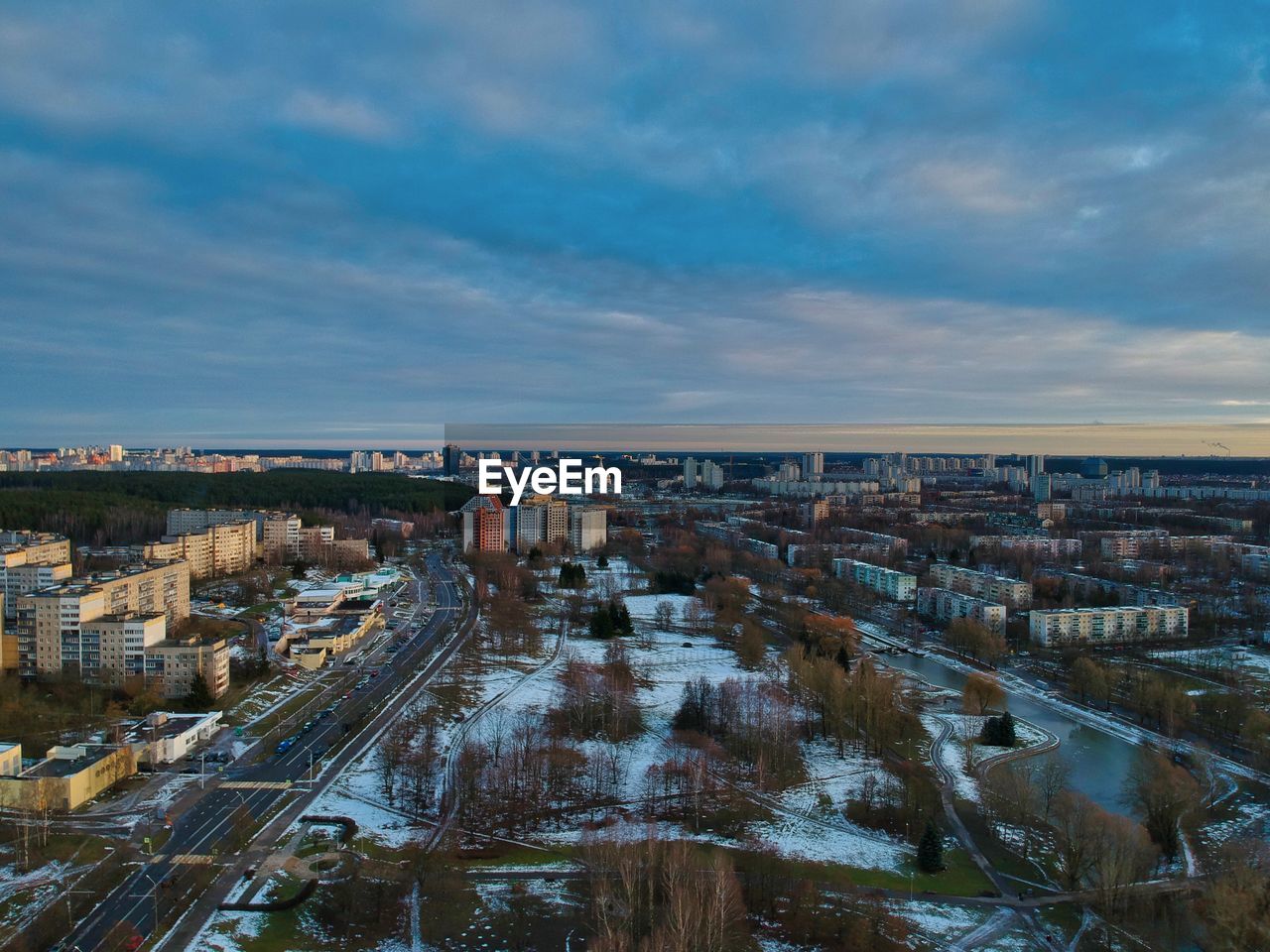 High angle view of city buildings against cloudy sky