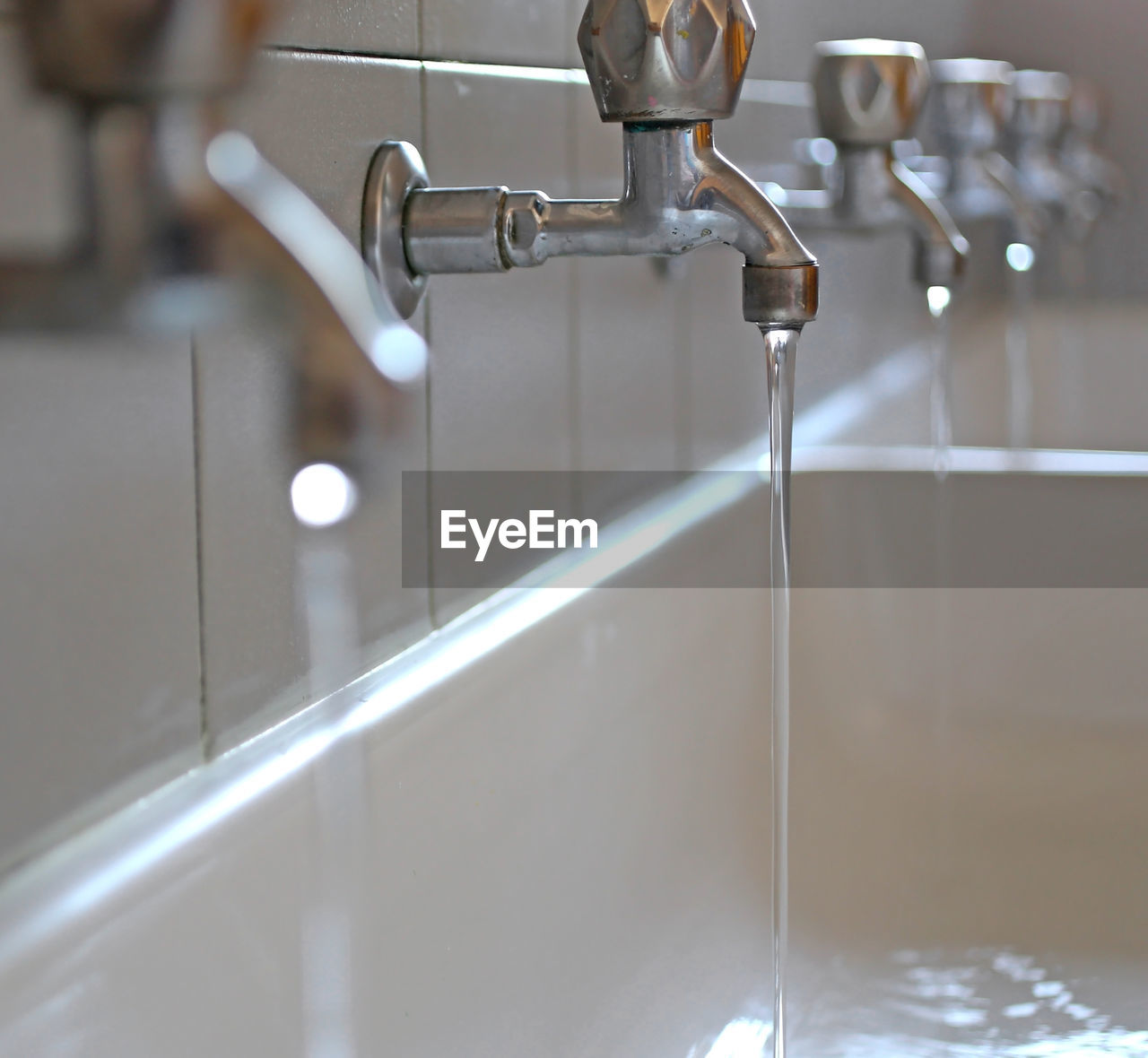 Close-up of running taps in bathroom