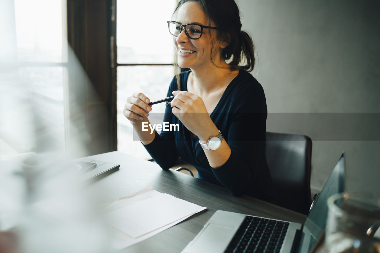 Smiling female entrepreneur in board room at office