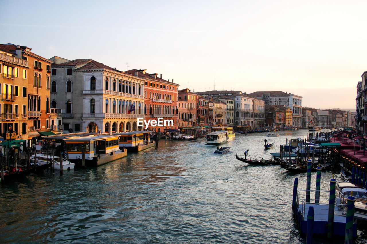 Venice form the rialto bridge at sunset. gondolas and boats in canal grande between historic palaces