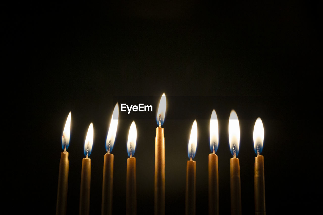 Close-up of burning golden hanukah candles