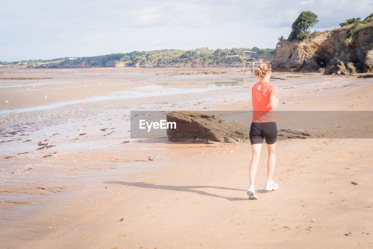 Full length of woman jogging at beach